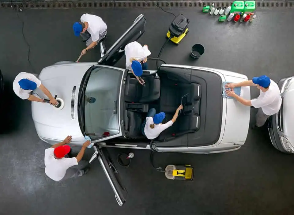 many detailers cleaning a cabriolet