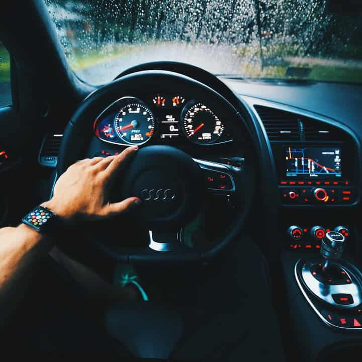 hand on a Audi steering wheel on a rainy day